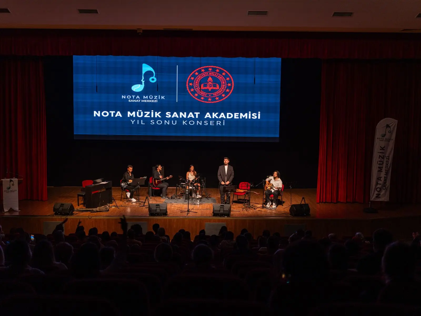 Yıl sonu konserinde dolu salon ve sahnedeki öğrenciler