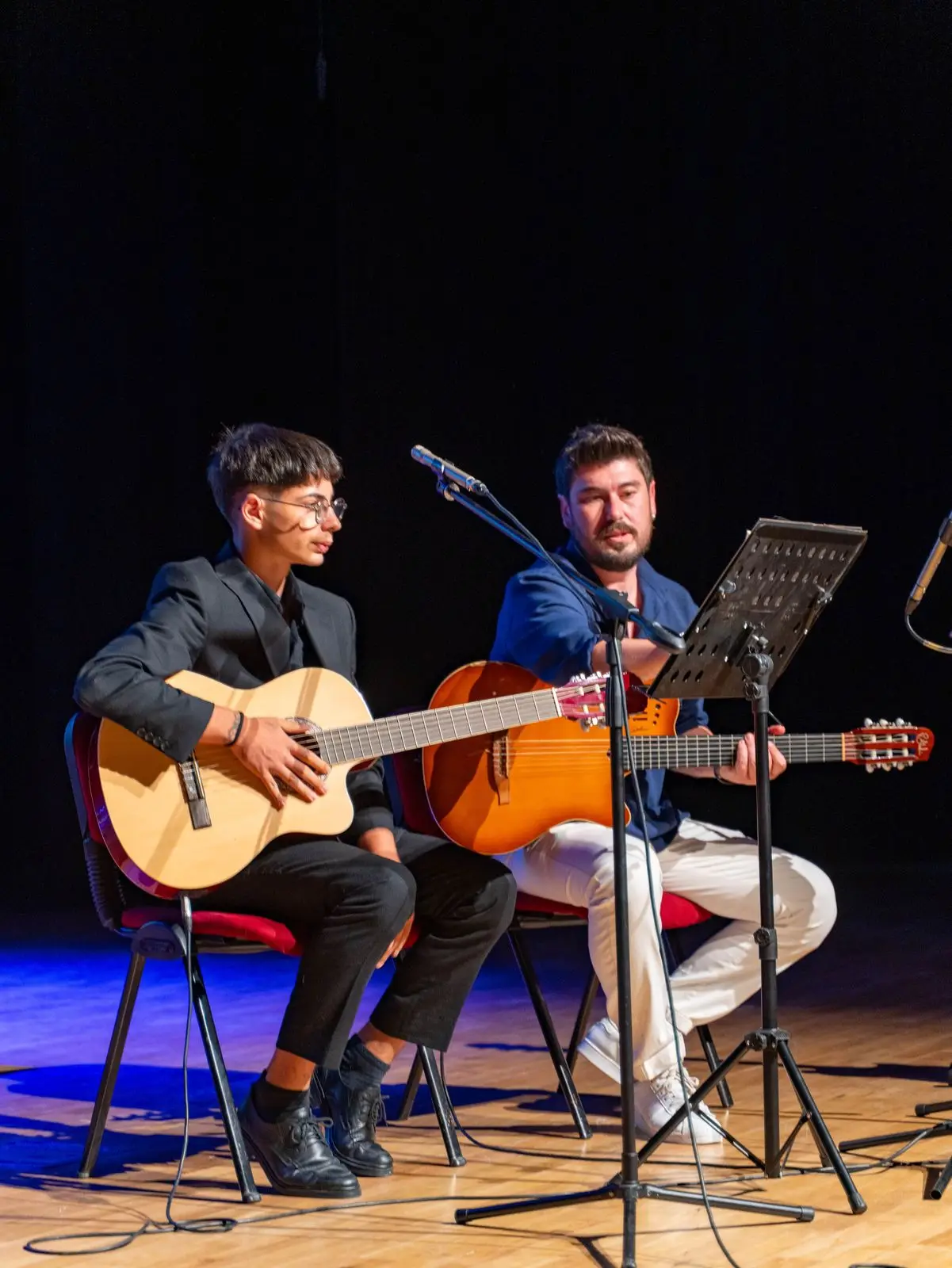Sahnede birlikte gitar çalan iki öğrenci
