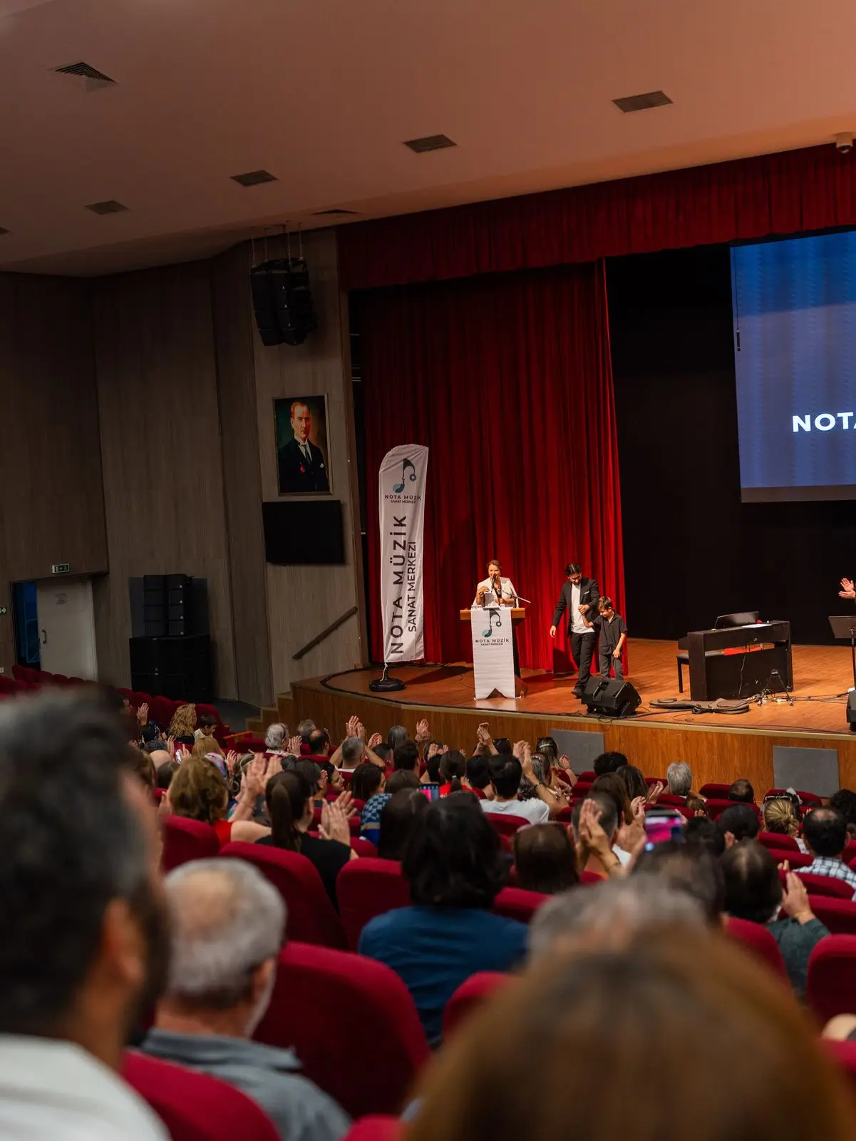 Konser salonunda performansı izleyen seyirciler