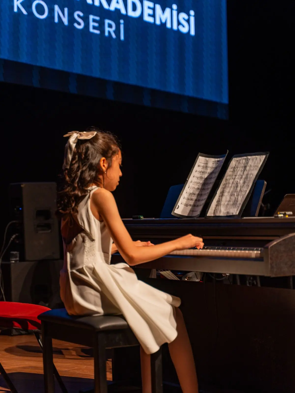 Konser piyanosunda çalan küçük bir öğrenci
