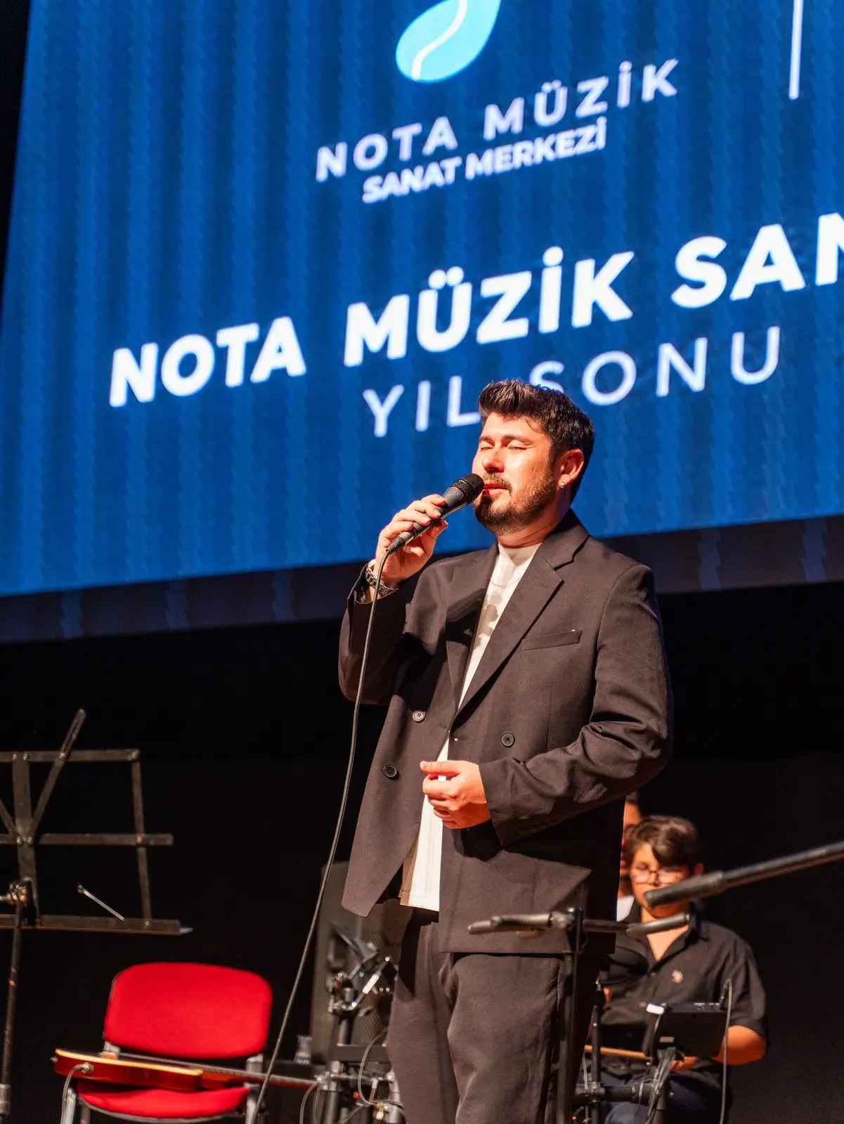 Konser sunumu sırasında sahnede konuşan eğitmen