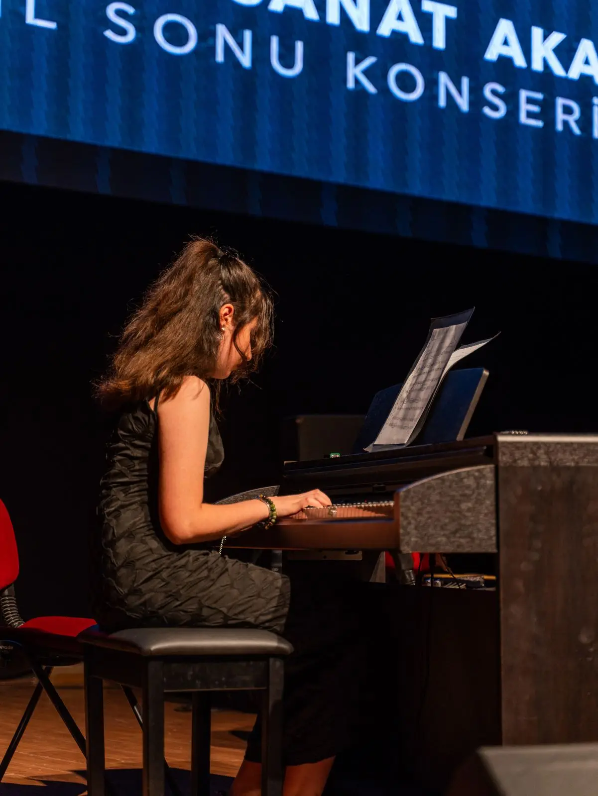 Konser piyanosunda çalan genç öğrenci