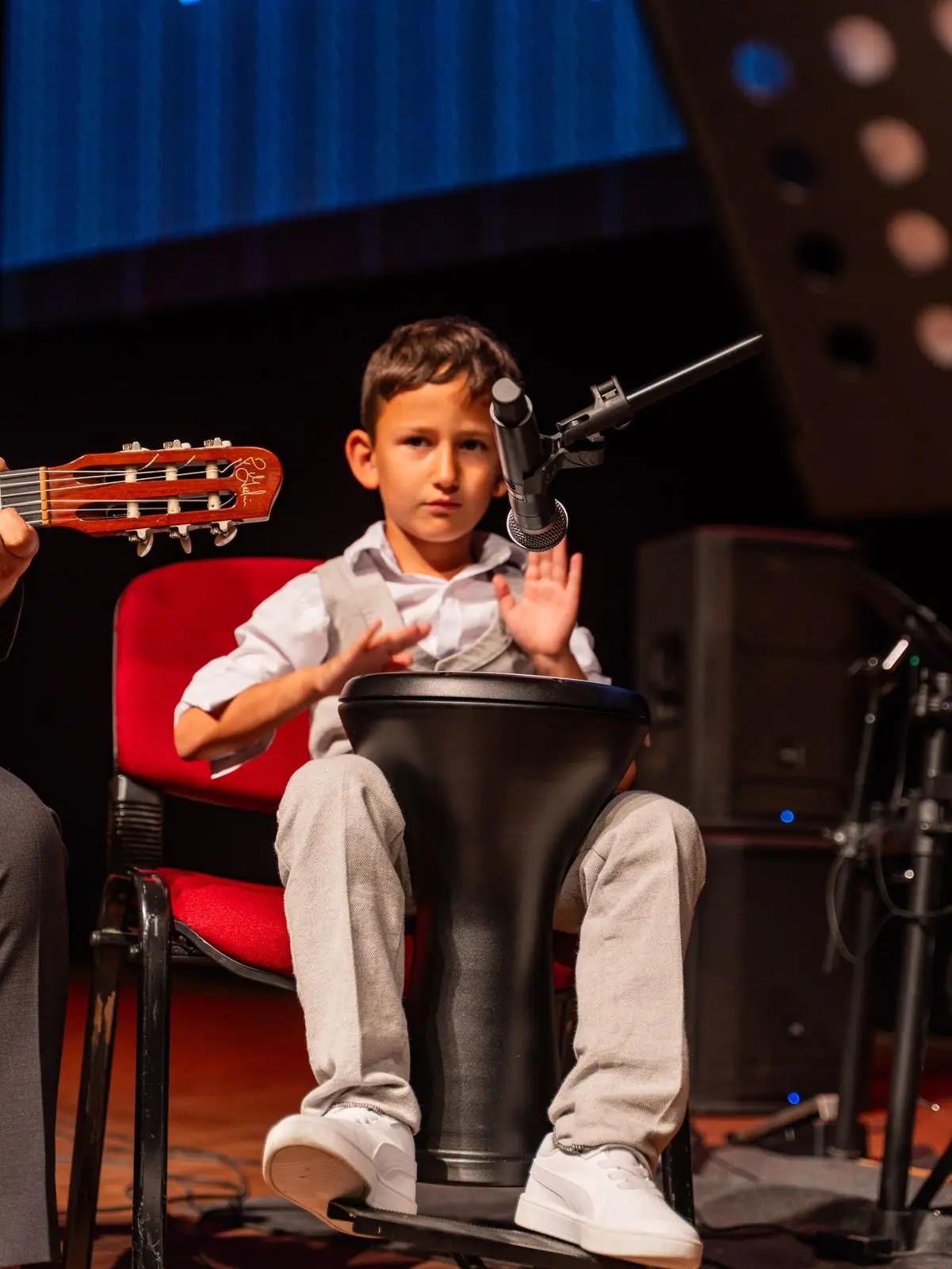 Sahnede darbuka çalan küçük öğrenci