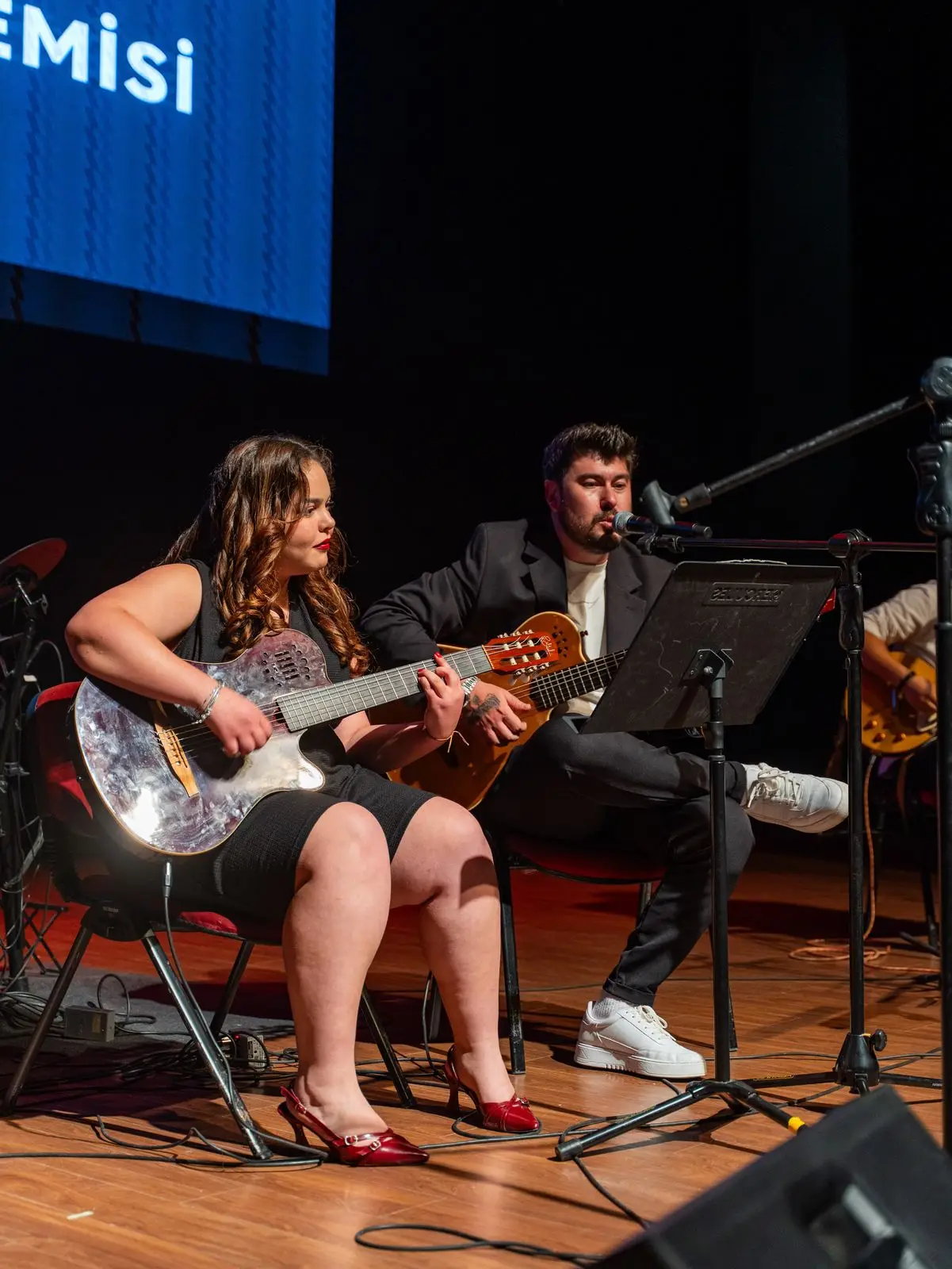 Gitarlarla sahnedeki öğrenci topluluğu